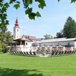 Schwimmbad mit Liegestühle und Kirche im Hintergrund